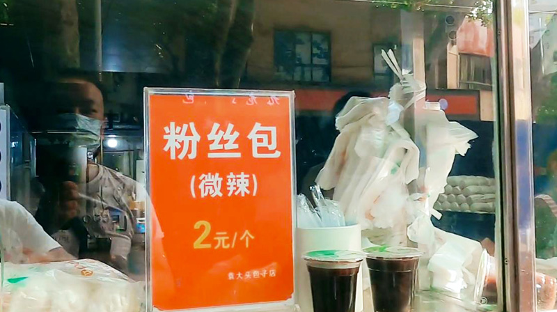 武汉闹市区有家老品牌包子店，松软可口的包子排队买，一买一大袋